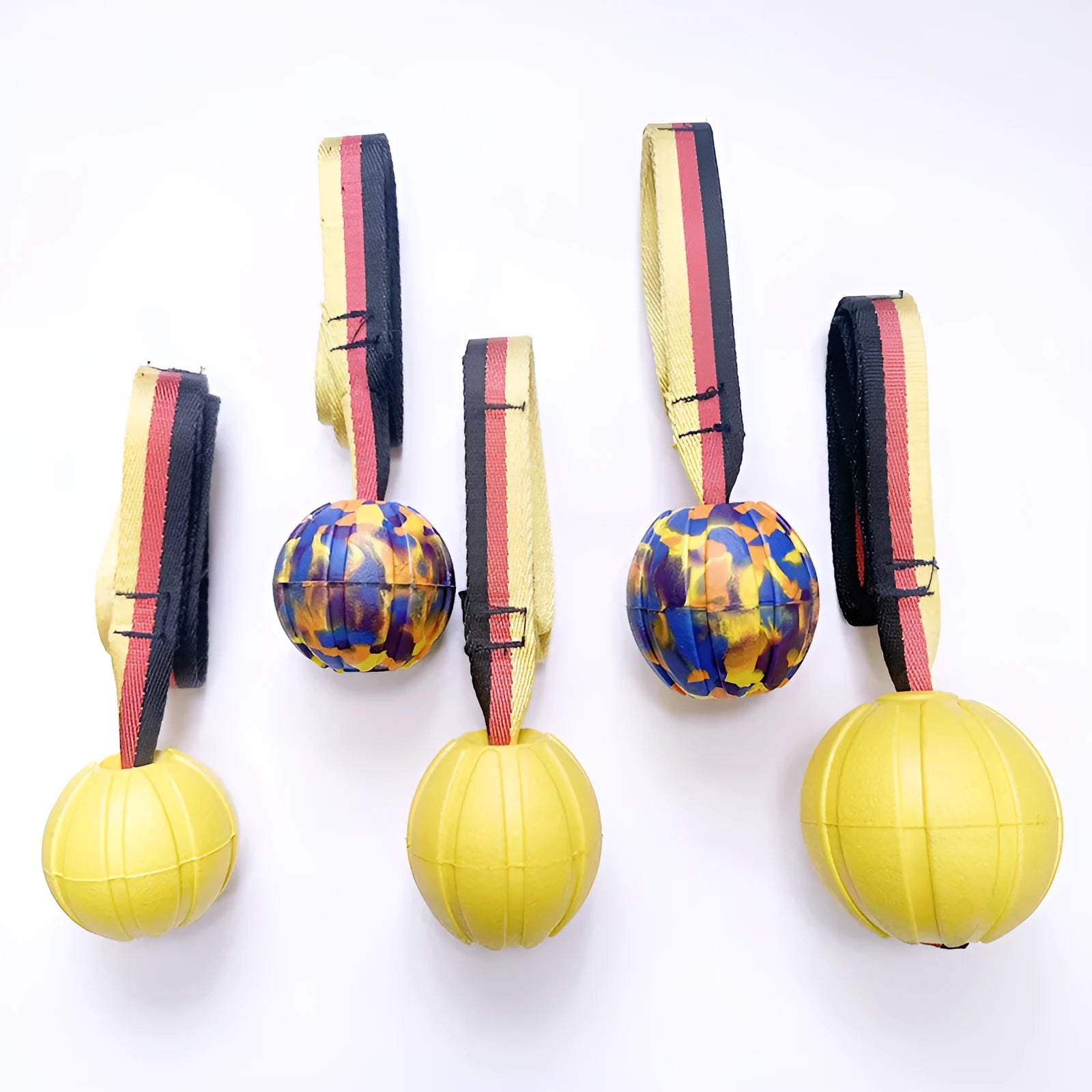 Yellow and camouflage coloured EVA foam floating dog ball with string attached for fetch and water training.