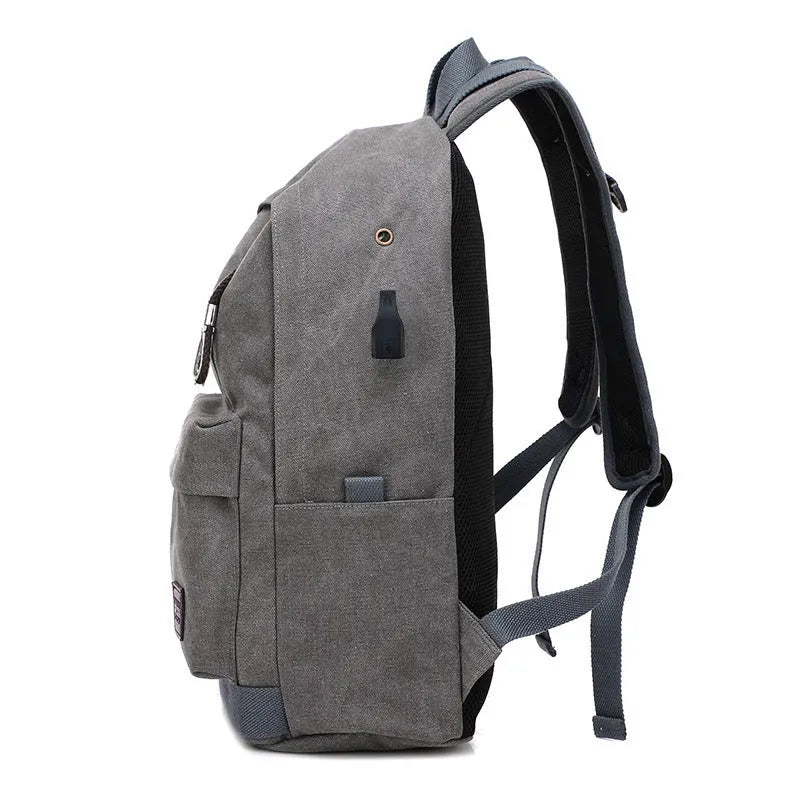 Canvas backpack with USB charging port showing multiple compartments including laptop pocket
