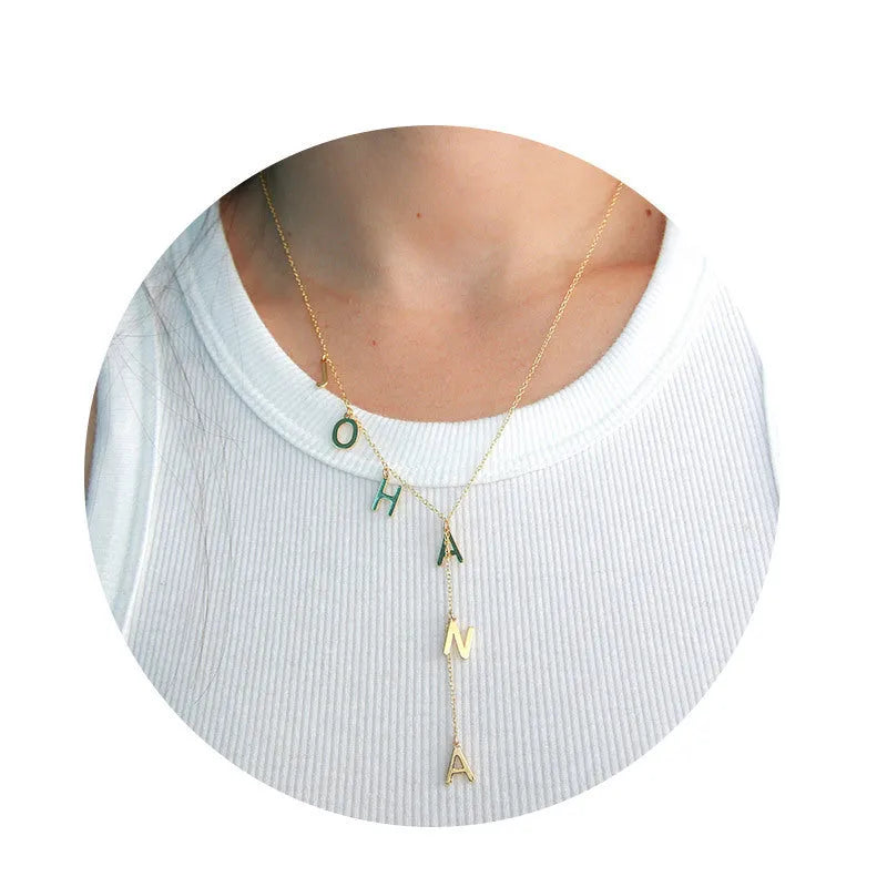 Gold lariat name necklace with bubble letters on adjustable chain, isolated on white background