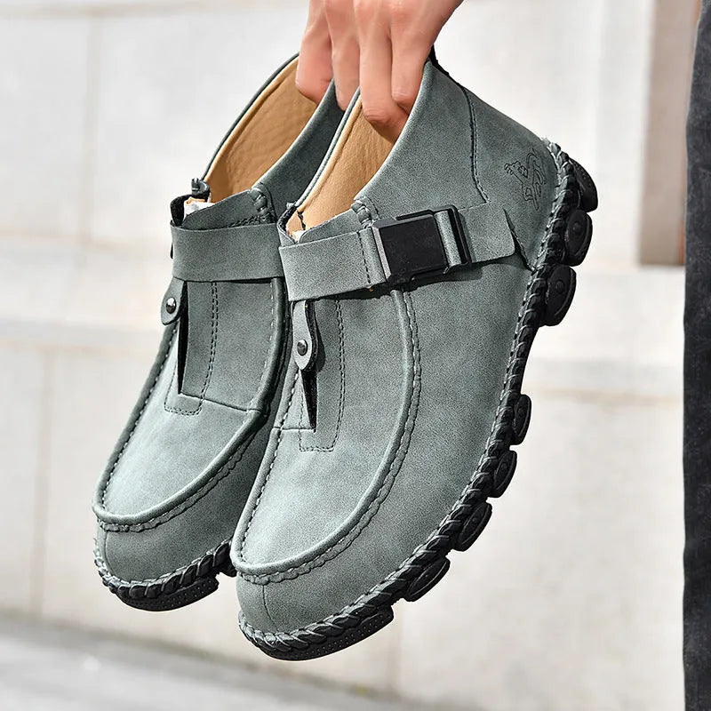 Men's black casual slip-on shoes with handmade stitching on the synthetic leather upper and a flat sole.