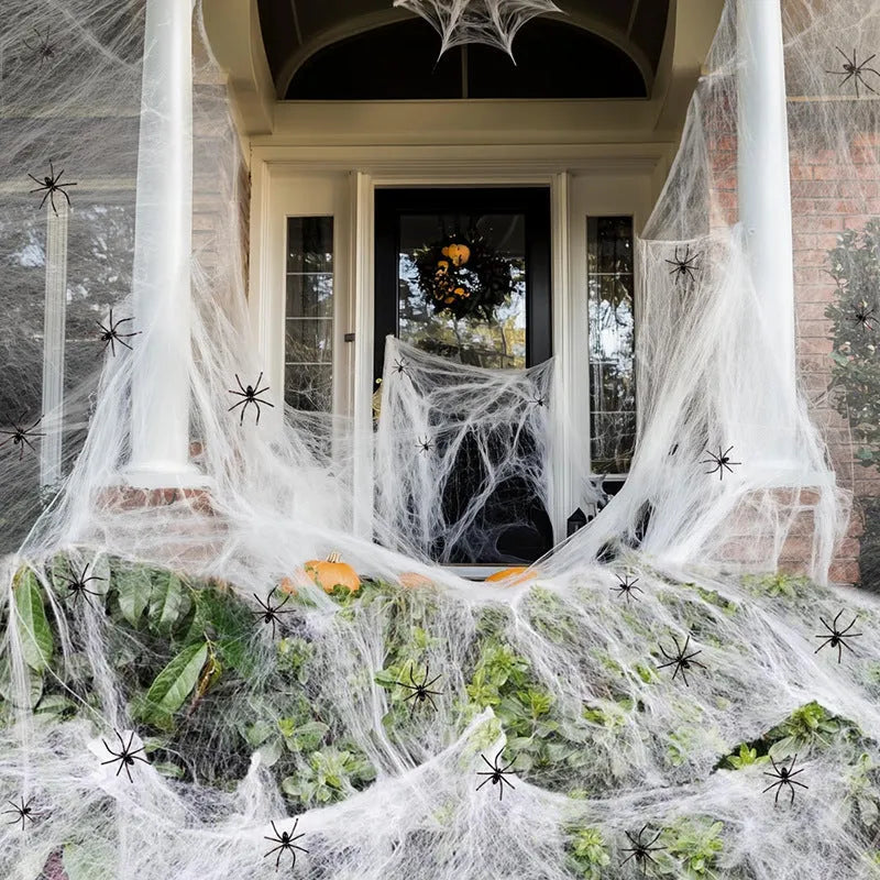 White cotton spider web Halloween decoration with plastic spiders draped over furniture