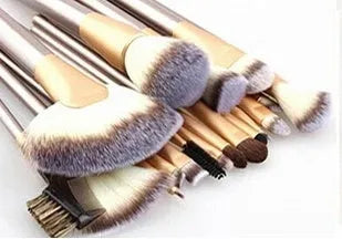 Champagne white synthetic fibre makeup brush set with wooden handles and aluminium ferrules on flat surface