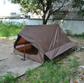 Brown or white A-line hiking tent pitched using hiking canes, showing spacious interior for 2-3 people.