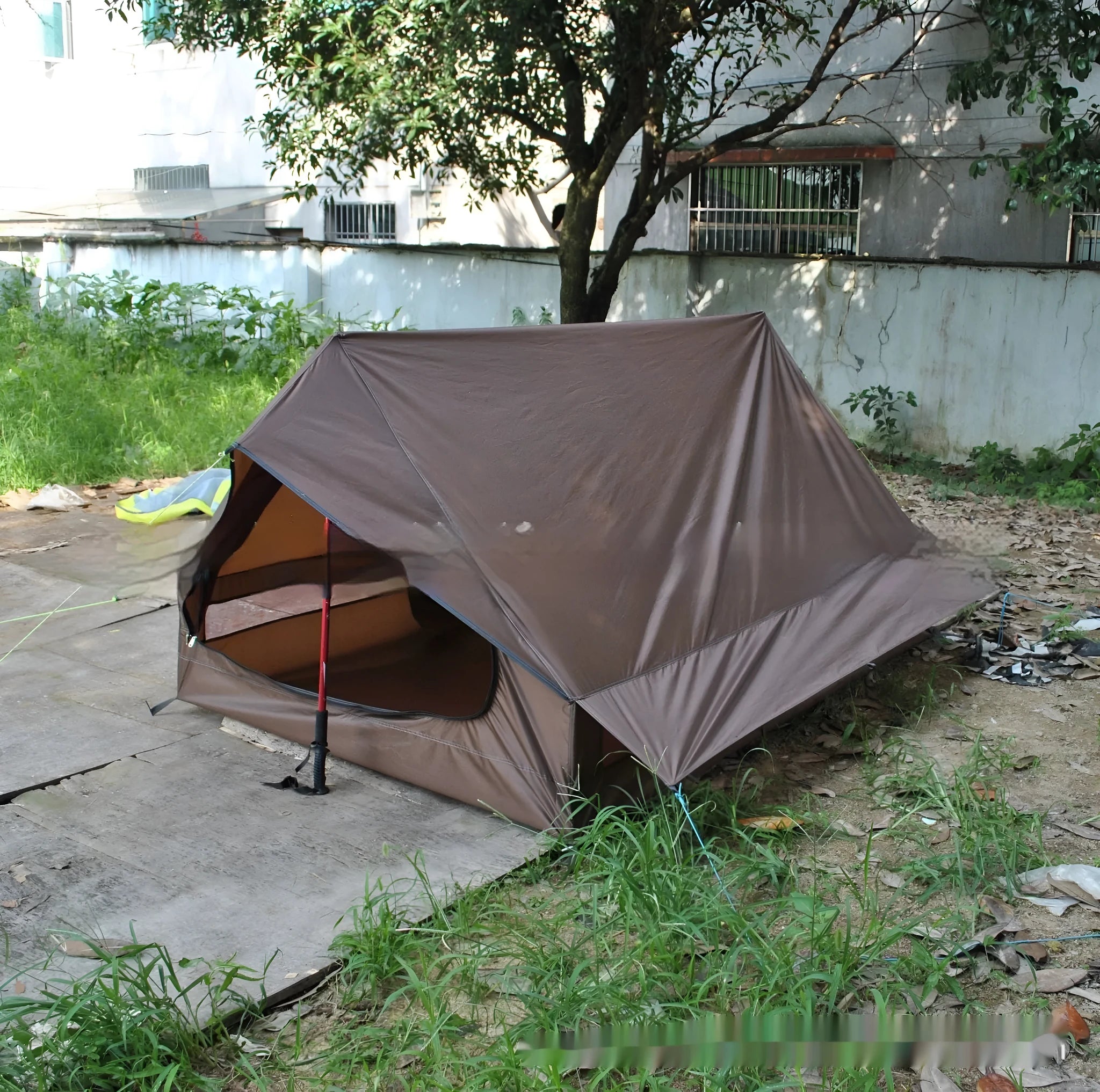 Brown or white A-line hiking tent pitched using hiking canes, showing spacious interior for 2-3 people.