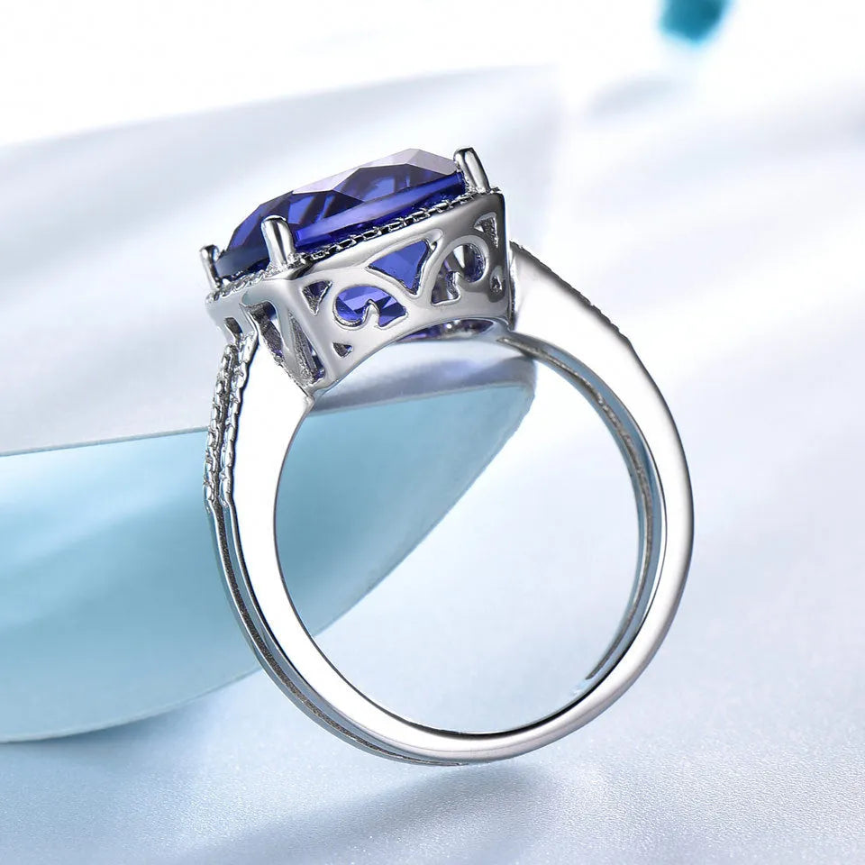 Women's sterling silver ring with blue tanzanite stone showing silver band and gemstone setting
