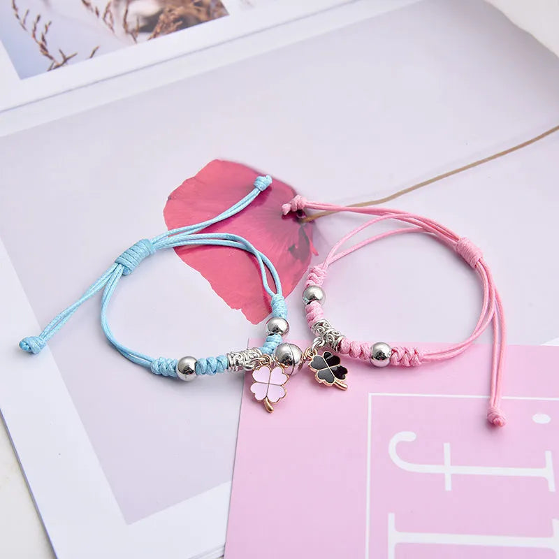 Pair of magnetic suction bracelets with alloy charms in various love and friendship themed designs on a wrist.