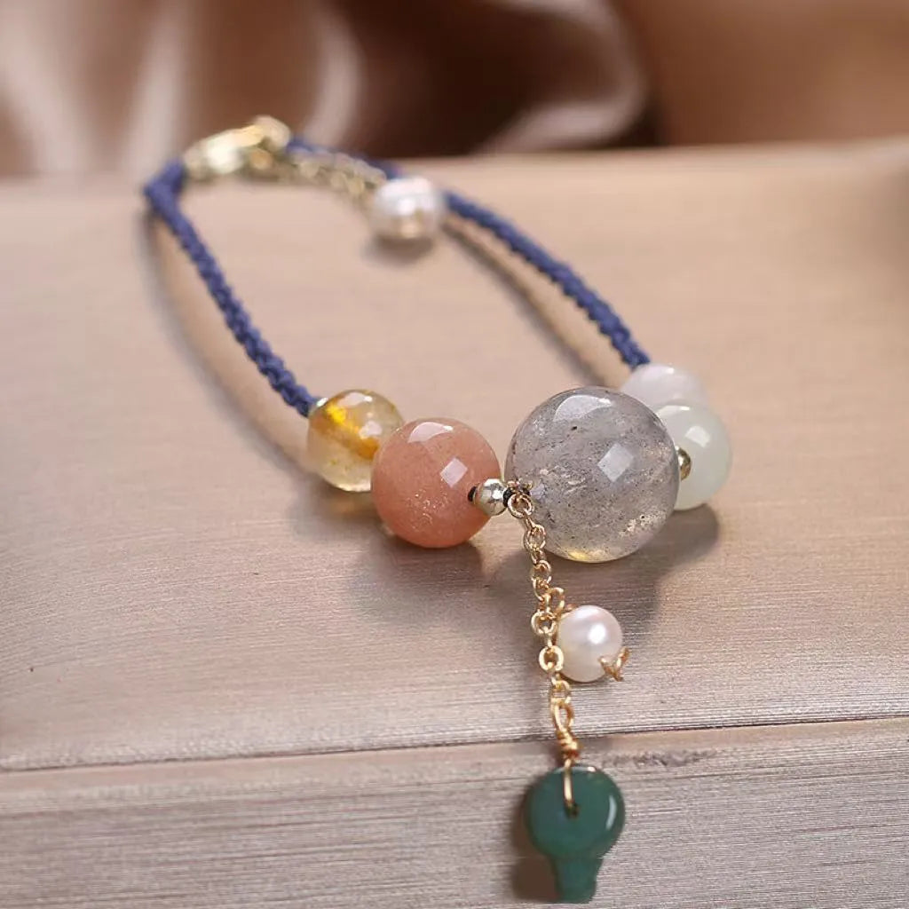 Women's hand-woven bracelet with peace buckle closure and crystal sequins in red, green, and blue colour options