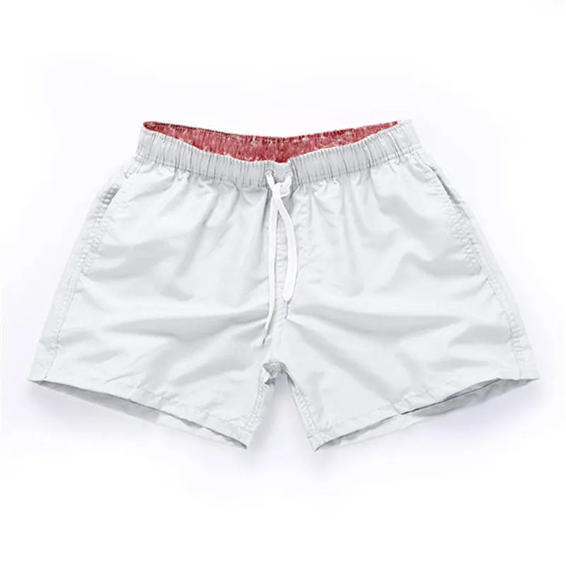 Men's black surf shorts made from polyester fabric with a straight leg opening, shown on a size chart.