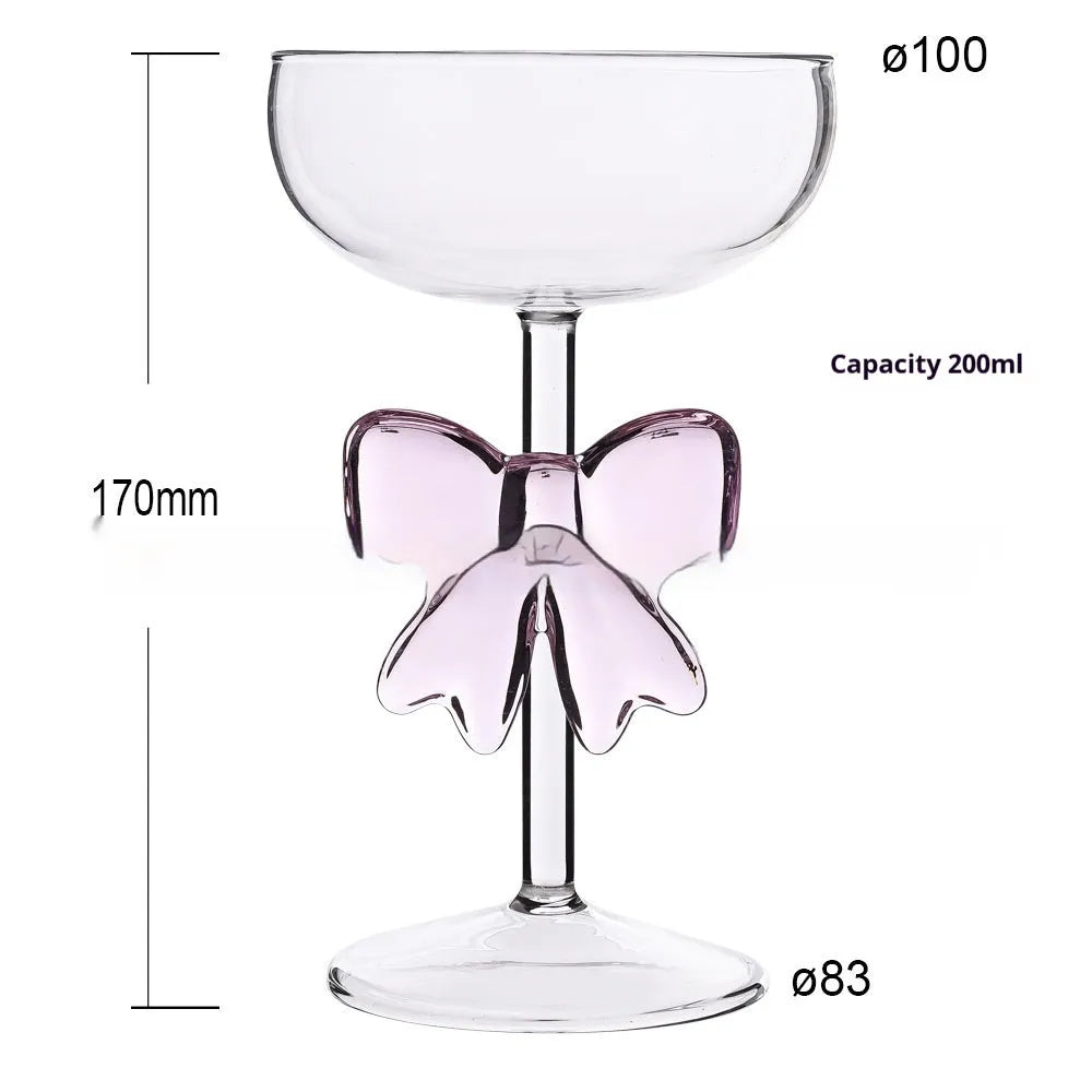 Set of three clear borosilicate glass candlesticks with large bow decorations on a table