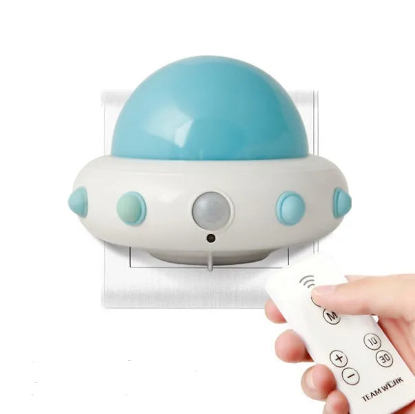 Remote control UFO shaped bedside night light in blue, pink, or white with cartoon design