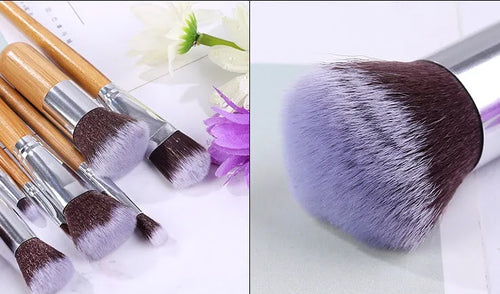 11 bamboo handle makeup brushes arranged on linen bag, including foundation blush and eye shadow brushes