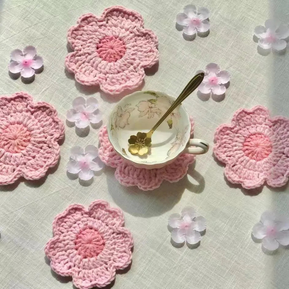 Set of hand-woven wool coasters on a wooden table surface