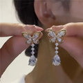 A pair of platinum-coloured bow-shaped stud earrings on a zinc alloy base.