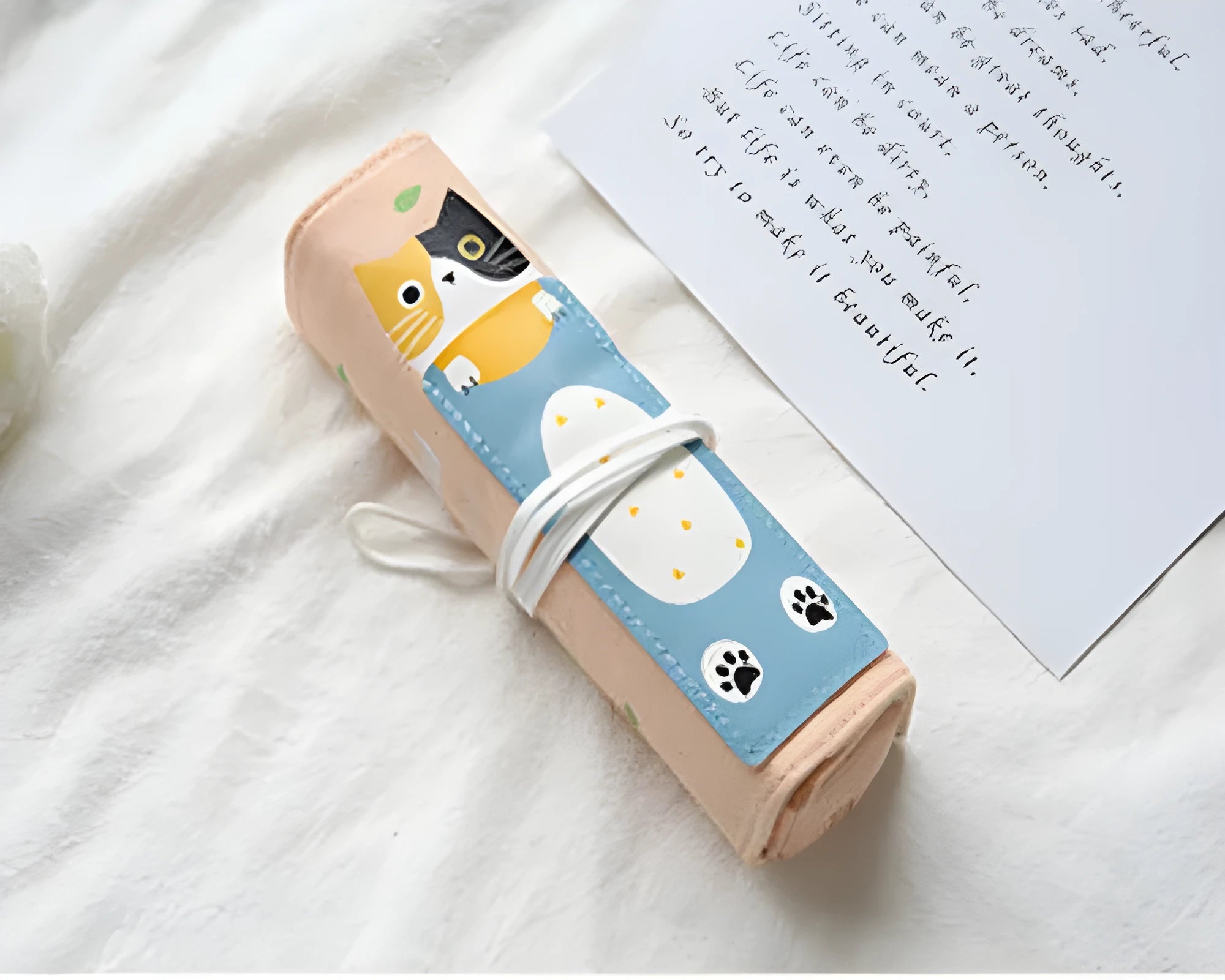 Rolling pencil case with grass green cat pattern on a school desk