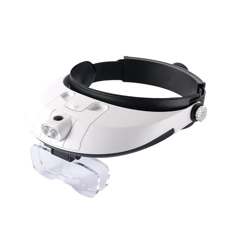 LED headband magnifier model 81001-G with interchangeable lenses and lights on a workbench.