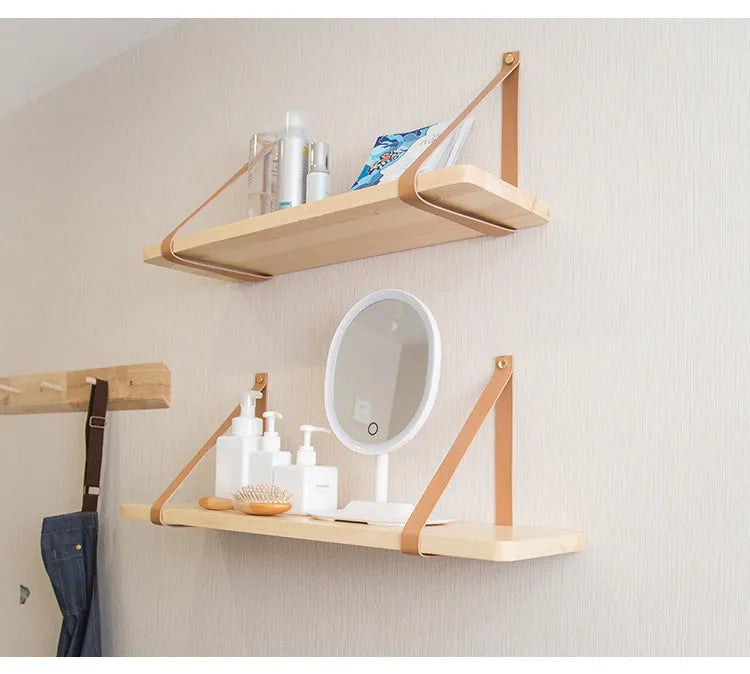 Solid pine wood wall mounted storage shelf in Nordic style, 50cm wide, holding remote controls and books.