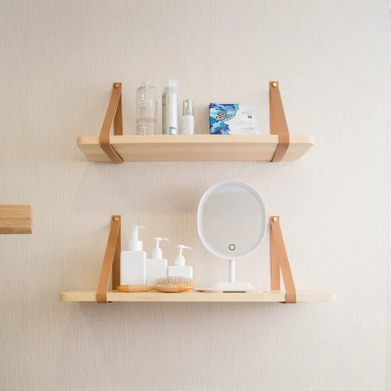 Solid pine wood wall mounted storage shelf in Nordic style, 50cm wide, holding remote controls and books.
