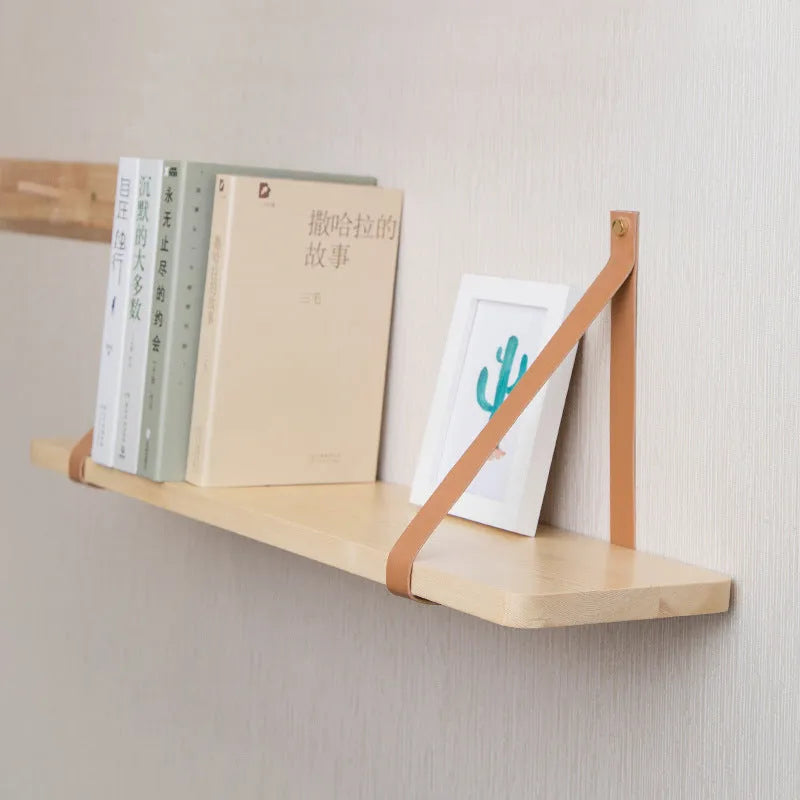 Solid pine wood wall mounted storage shelf in Nordic style, 50cm wide, holding remote controls and books.