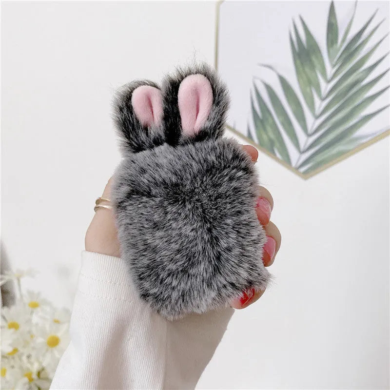 Pink rabbit ear silicone protective cover for Apple AirPods Pro case on a grey background.