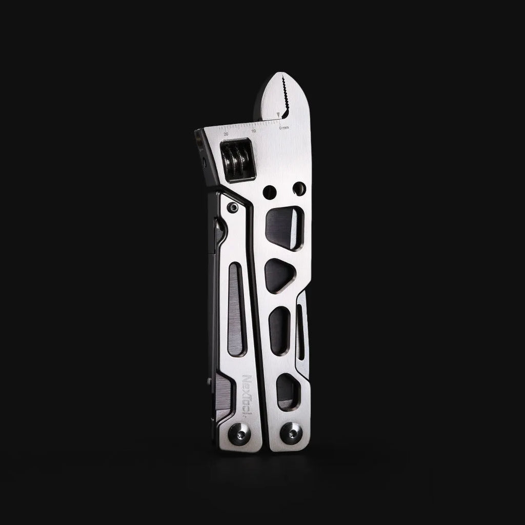 White stainless steel multi-tool with wrench, knife blade, and needle-nose pliers on a plain background.