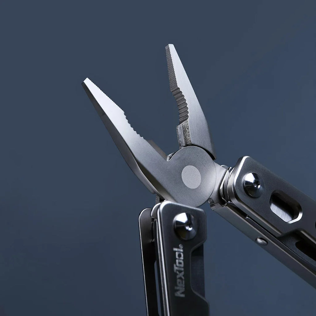 White stainless steel multi-tool with wrench, knife blade, and needle-nose pliers on a plain background.