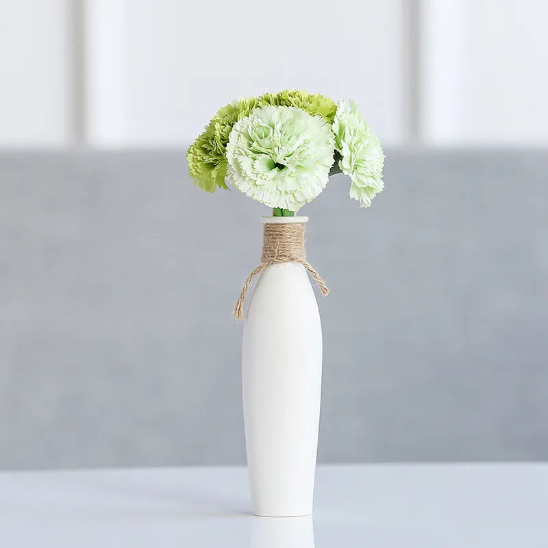 Modern simple ceramic vase with artificial dried flower arrangement on a countertop, medium size