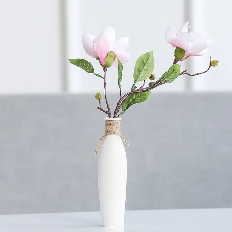 Modern simple ceramic vase with artificial dried flower arrangement on a countertop, medium size