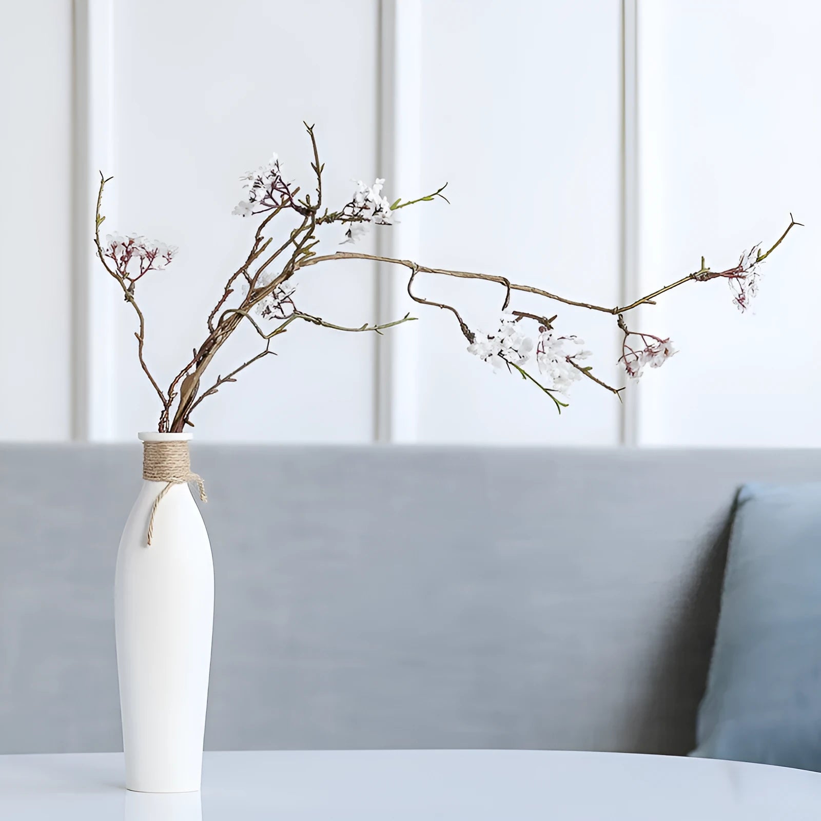 Modern simple ceramic vase with artificial dried flower arrangement on a countertop, medium size