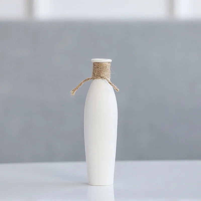 Modern simple ceramic vase with artificial dried flower arrangement on a countertop, medium size