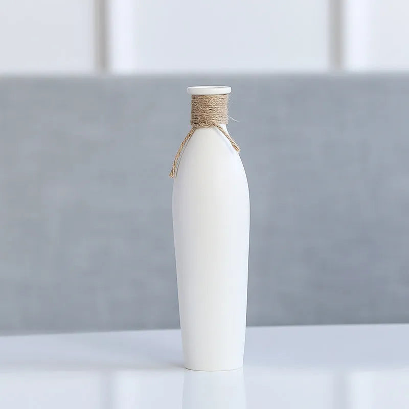 Modern simple ceramic vase with artificial dried flower arrangement on a countertop, medium size