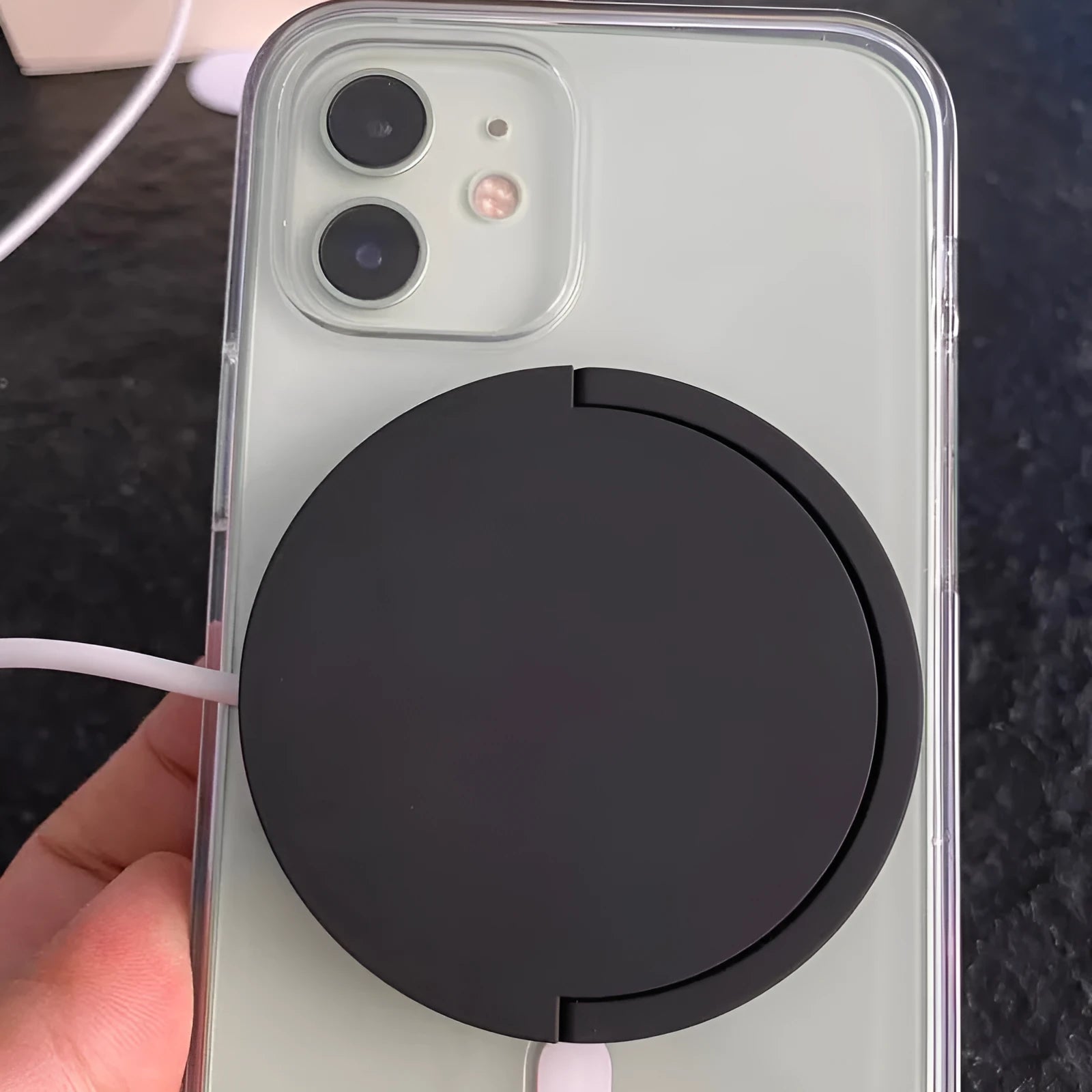 Black magnetic car phone holder with wireless charging showing phone attachment