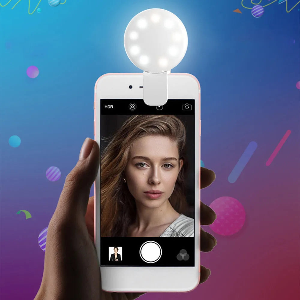 White round clip-on mini fill light attached to a mobile phone for selfies.