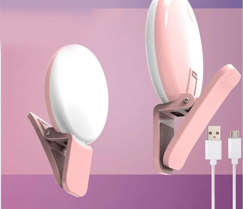 White round clip-on mini fill light attached to a mobile phone for selfies.