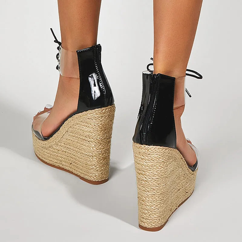 Black women's wedge sandals with hemp rope detail on the upper and a high platform sole, showing front tie closure.
