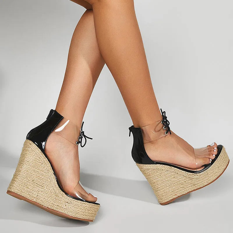 Black women's wedge sandals with hemp rope detail on the upper and a high platform sole, showing front tie closure.