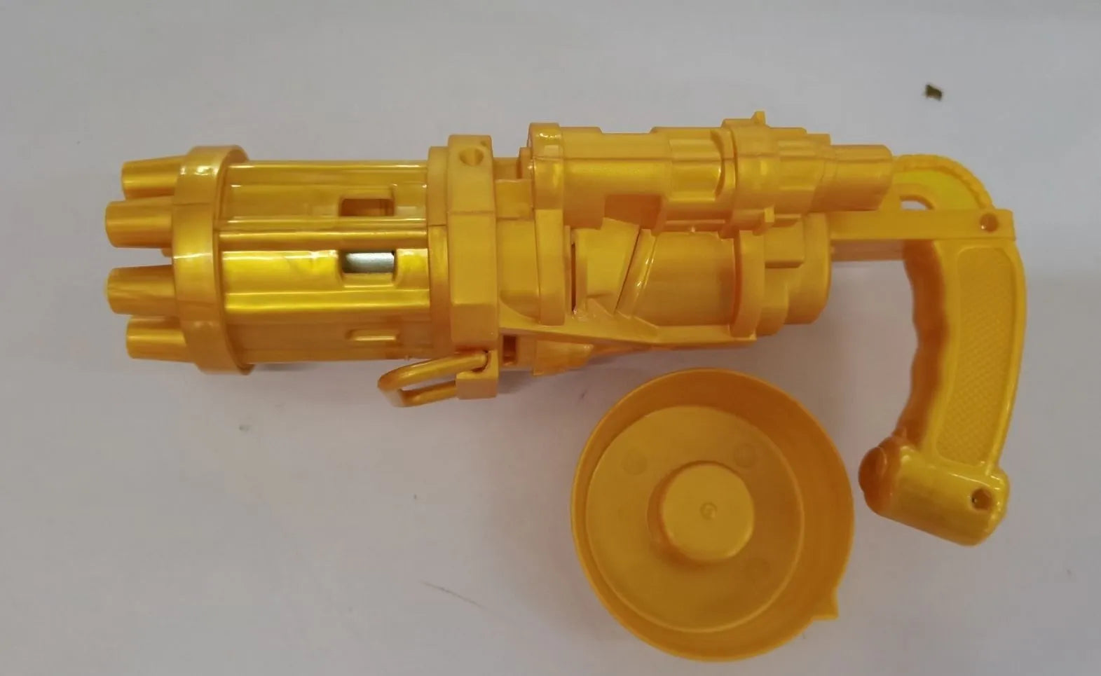 Realistic pink bubble machine gun toy for kids on a green lawn.