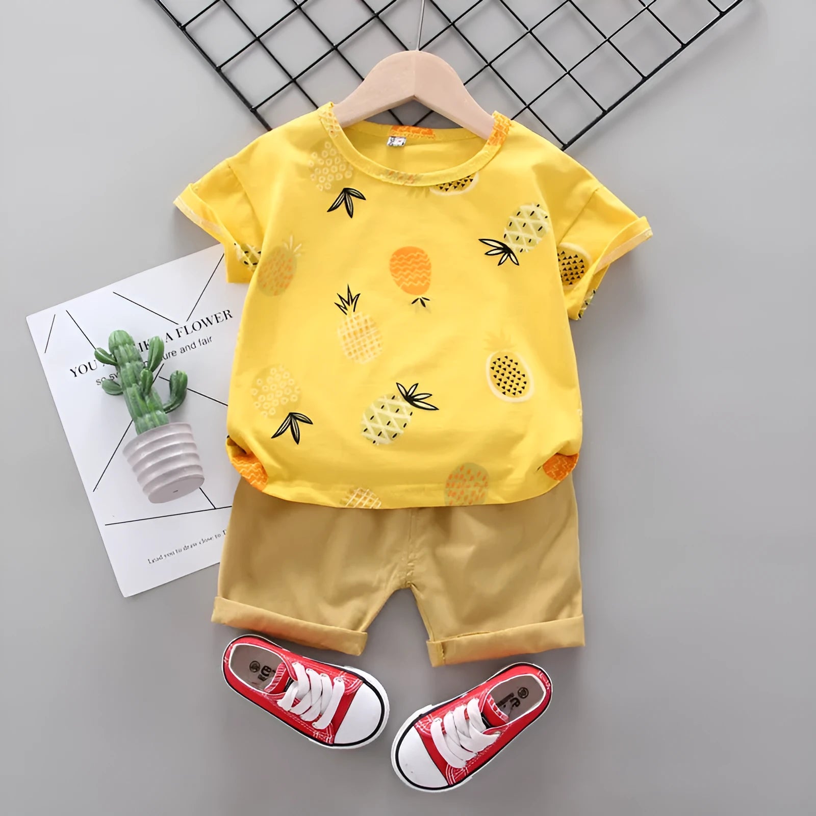 White cotton short-sleeve summer suit set for boys and girls with cartoon print, flat lay