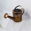 Enchanted watering can solar lamp with warm white star-shaped LED lights in a garden setting