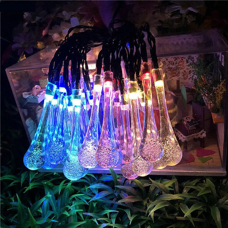Solar-powered LED outdoor string lights with water drop-shaped pendants in garden setting