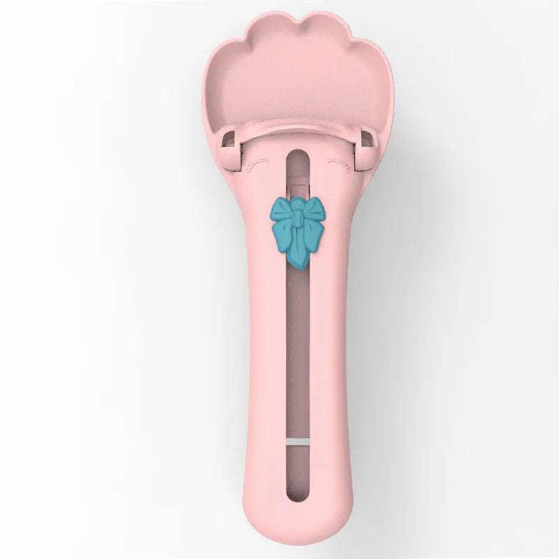 Pink and green pet feed spoon with squeezer mechanism for wet food and treat dispensing
