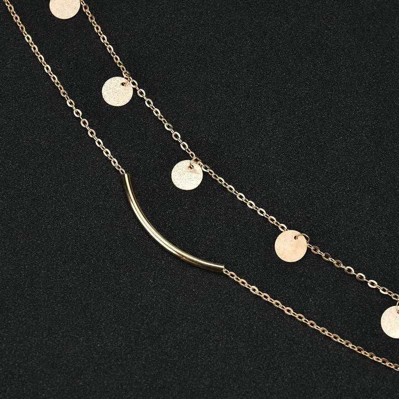 Gold alloy geometric pendant necklace with multi-sequin finish on display
