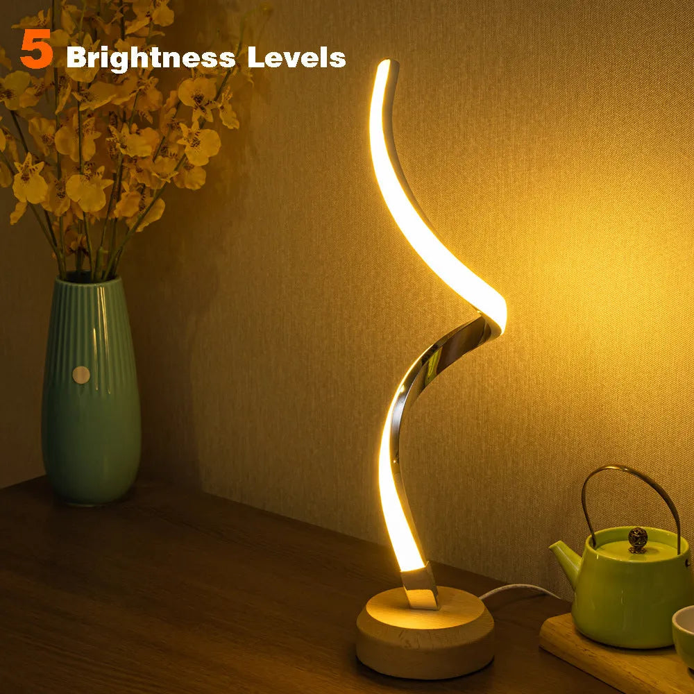 LED spiral table lamp with wooden curved base and USB cable, glowing warm white light