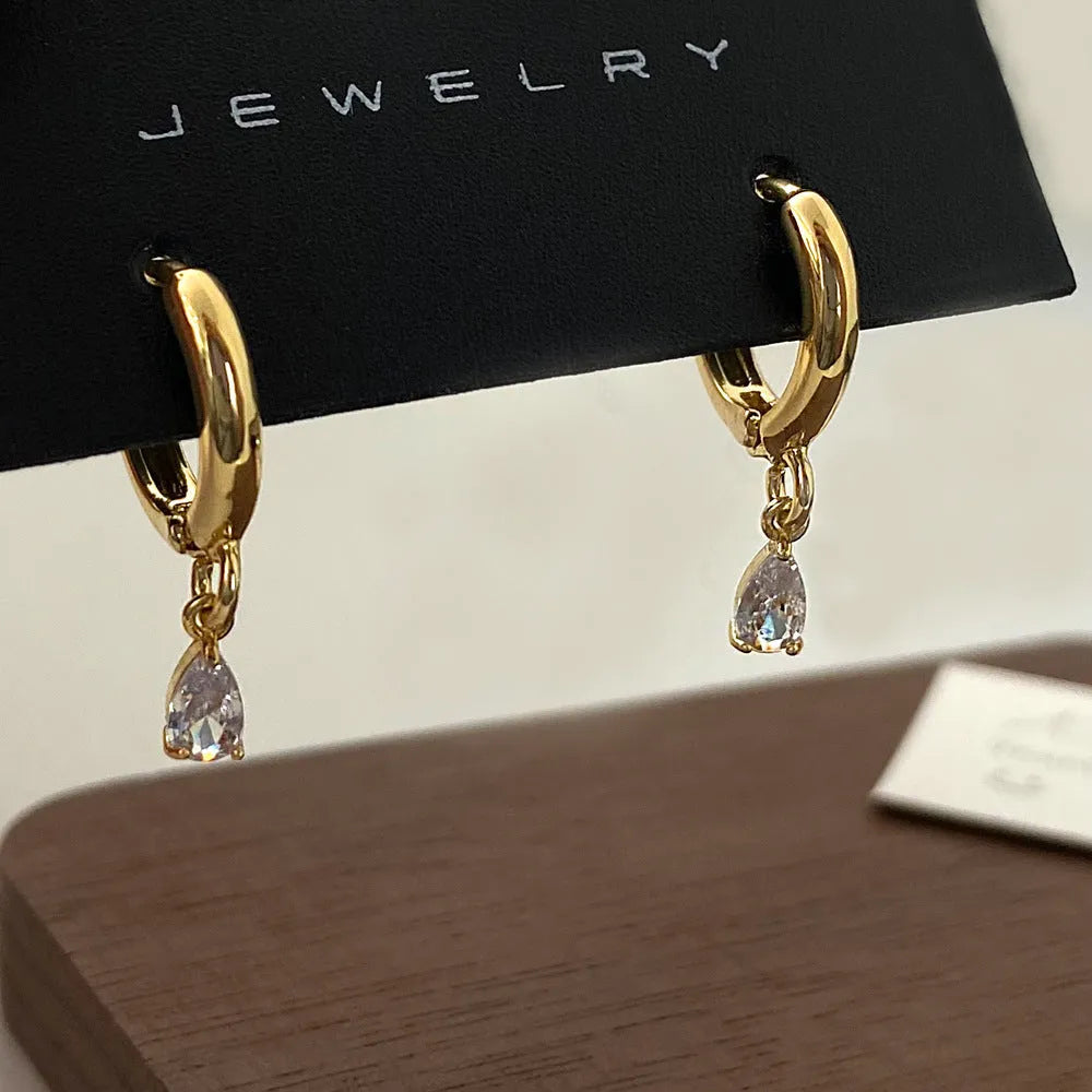 Women's zircon jewellery set showing geometric pendant necklace, matching earrings, and anklet on a white background.