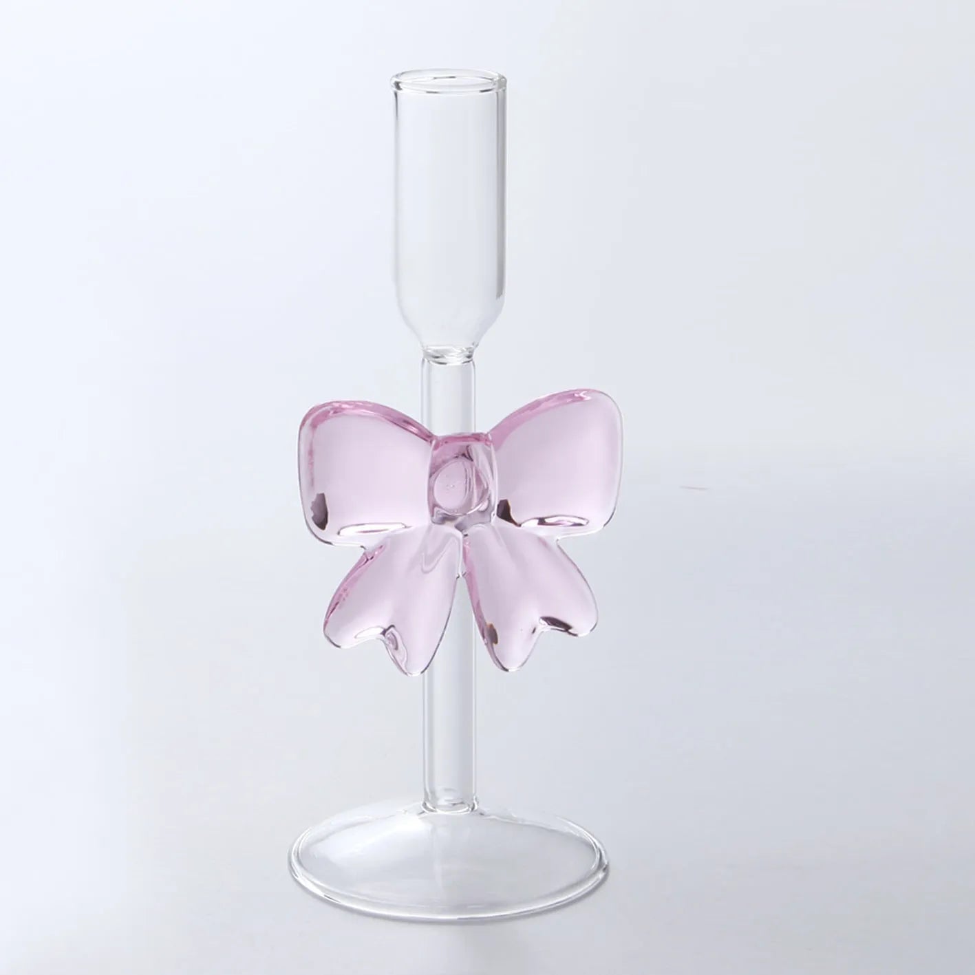 Set of three clear borosilicate glass candlesticks with large bow decorations on a table