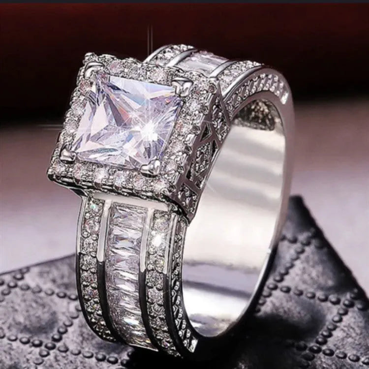Geometric silver-toned women's fashion ring in gold or white colour on a grey background.