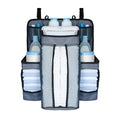 Gray baby diaper organizer hanging on a crib rail with compartments for nappies and wipes