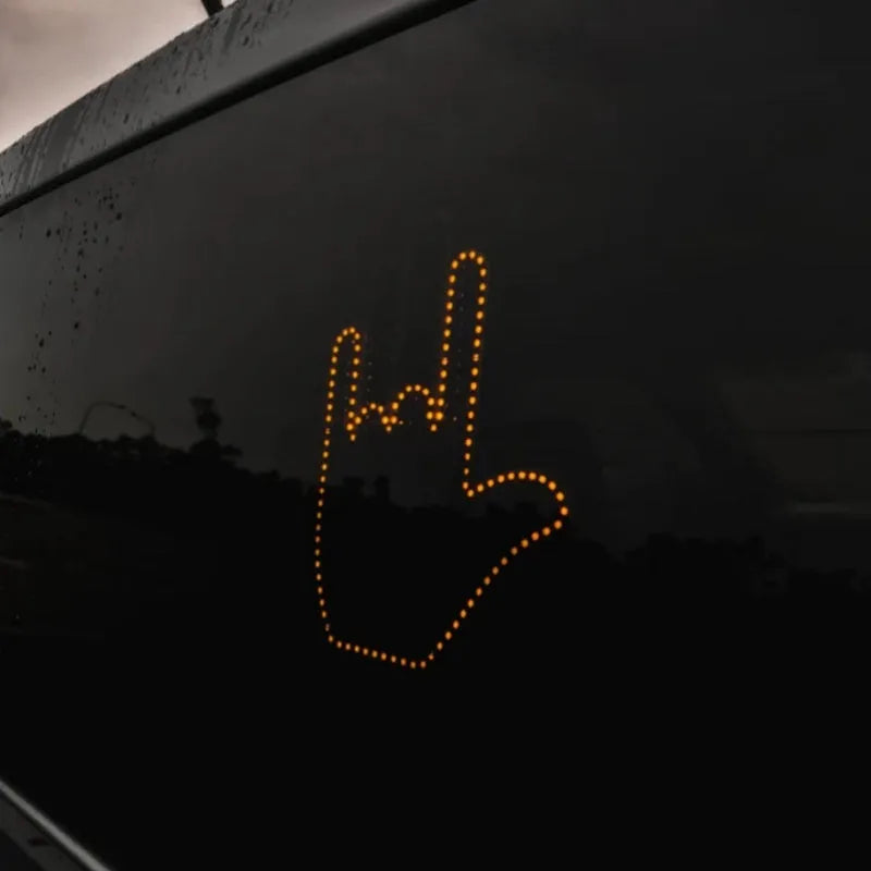 Black plastic car gesture light with LED illuminated hand gesture, remote control, and 3M Velcro mounting