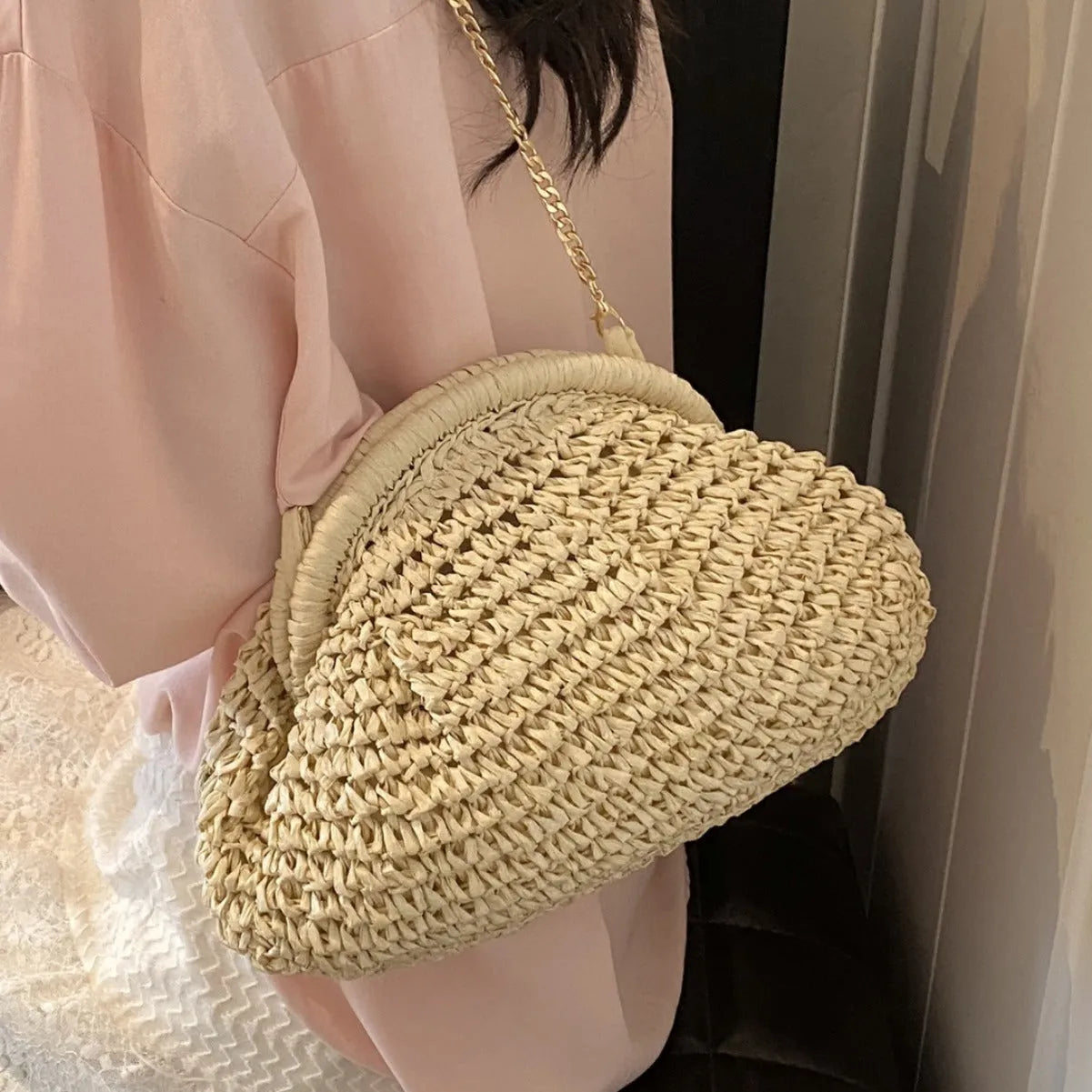 Women's khaki paper straw shoulder bag with chain strap and shell shape showing internal zippered compartment