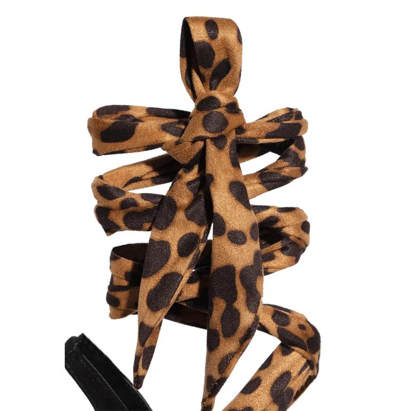 Light brown women's high heels with leopard print and Roman cross straps on a super high heel.