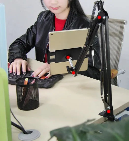 Black adjustable phone and tablet stand holding a mobile device on a desk.
